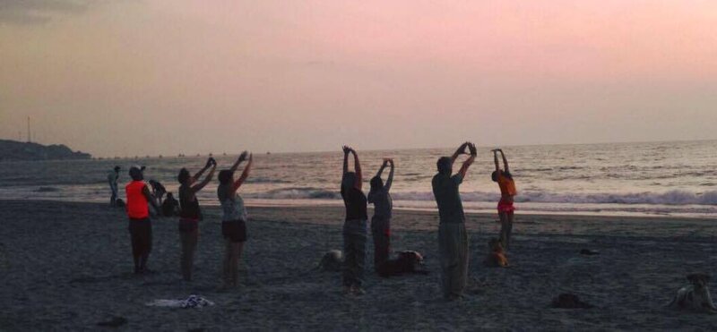 Yoga grupal en la playa al atardecer